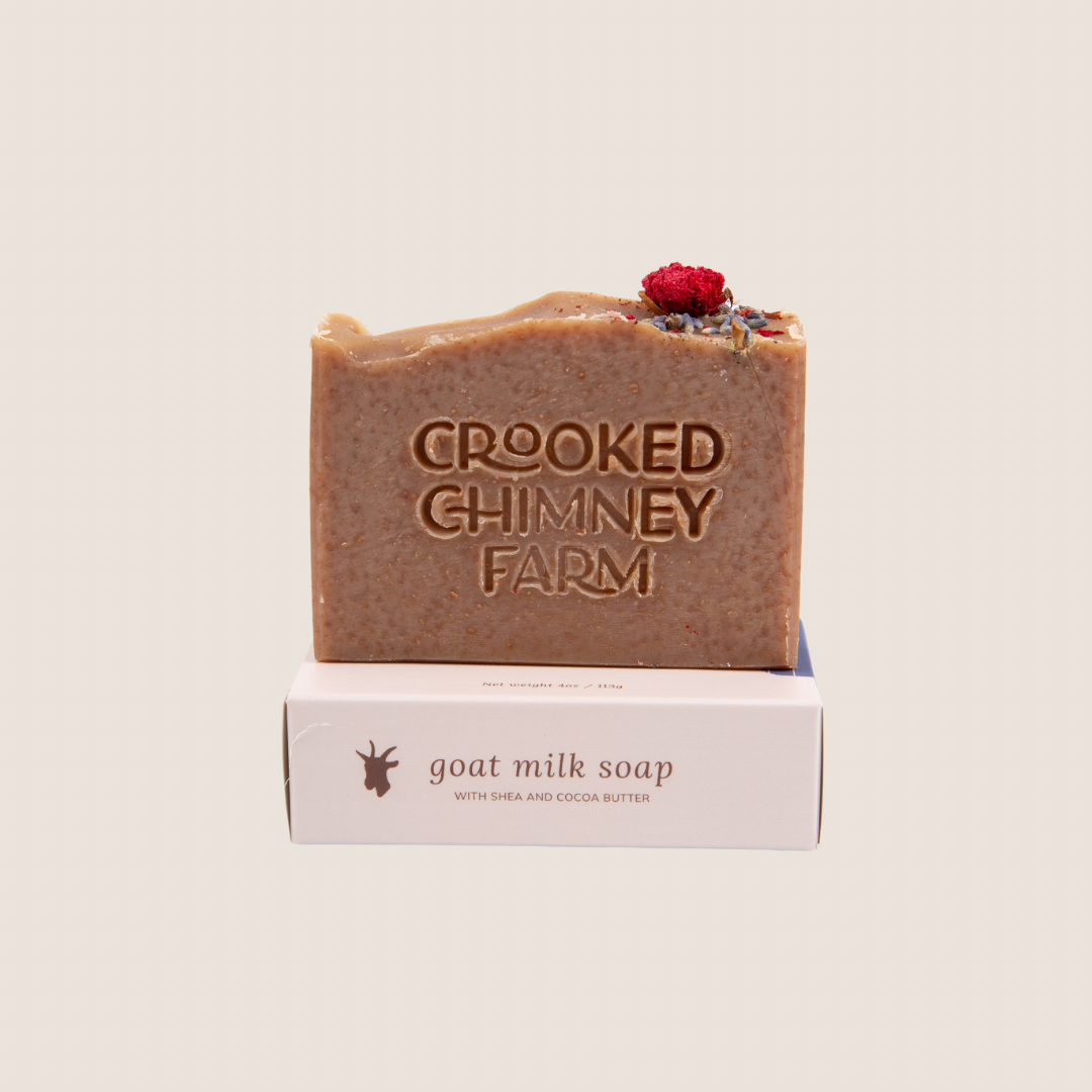 A bar of crooked chimney farm Moonlit Garden goat milk soap set on top of soap box