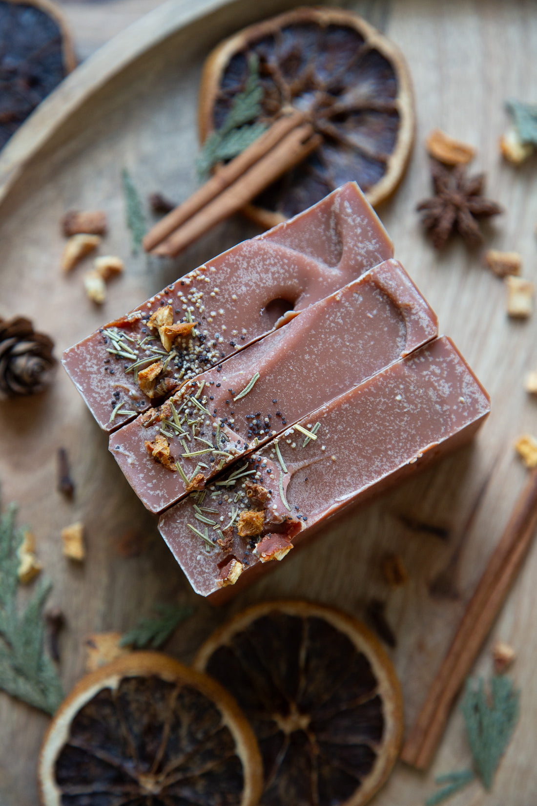 winter spice goat milk soap on cement soap dish. Spices in the background.