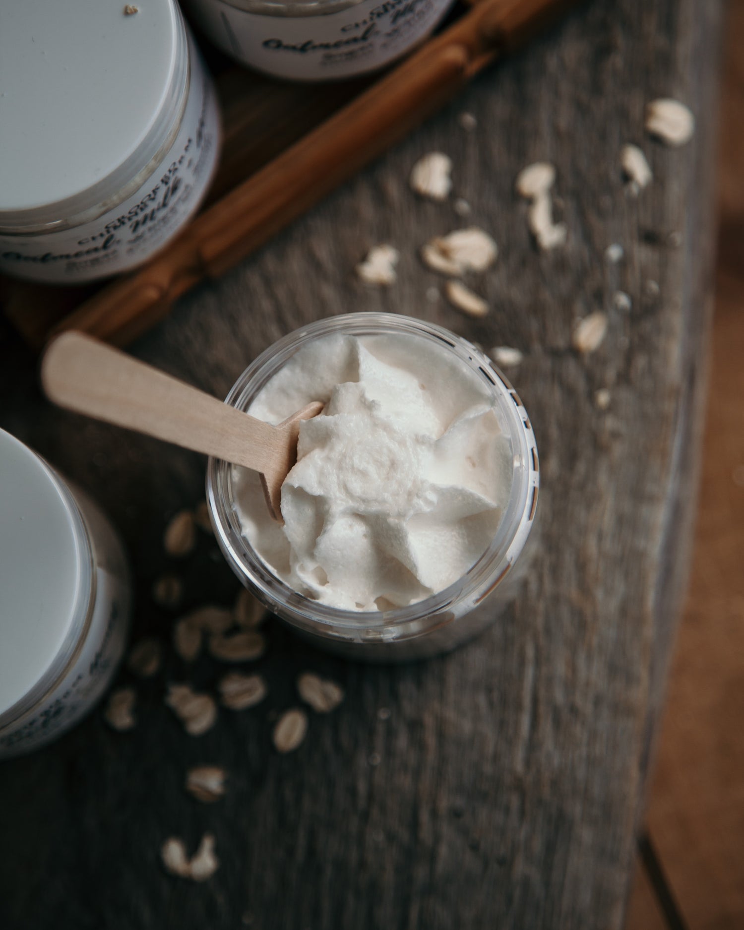 oatmeal milk and honey sugar whipped soap, open jar with wood spoon